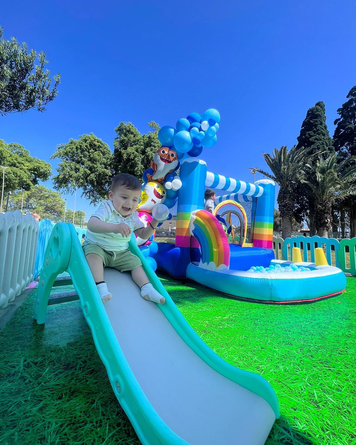 rainbow set with baby sliding down in the slide